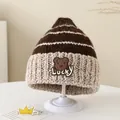 Dettaglio ravvicinato di un cappello invernale a maglia a righe con patch orsetto Lucky - 3-9 Anni / Caffè Scuro