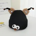 Detail of funny knitted baby hat with big white eyes and brown plush antennae - Black
