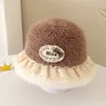 Detail of baby winter bucket hat with faux fur texture, lace trim and plaid bow detail - 52cm / Nice Label Style / Brown