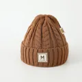 Détail d'un bonnet en maille torsadée marron avec écusson M et bord côtelé - Enfants (3-8 ans) / Café