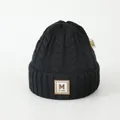 Dettaglio del berretto invernale in maglia grossa con patch in pelle M e trama a treccia - Bambini (3-8 anni) / Nero