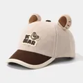 Detalle de gorra de invierno infantil con orejas de oso y parche con logo JC BEAR - Ajuste Elástico Para Niños Pequeños / Beige
