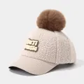 Detail of winter kids baseball cap with fluffy pom pom and BUTI MUSIC patch on corduroy brim - 3-6 Years / Beige
