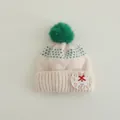 Detail of knit beanie showing lace applique with handmade embroidery and faux fur pompom - Kids 3-8 Years (Elastic) / Green Pom Pom