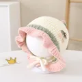 Detail of hand-crocheted baby bonnet featuring pink wavy edges and delicate floral accent - Toddlers 1-3 Years / White