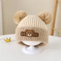 Close-up of knit baby bear hat with dual faux fur pom-poms and cute silicone patch - Beige Rainbow Stitching Style