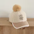 Detail of children's fleece baseball cap featuring a plush pom-pom and bear embroidery - 50-54cm / Beige