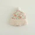 Dettaglio della trama in maglia colorata e del pompon bianco su questo cappello invernale - 2-5 Anni / Beige