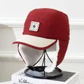 Close-up of winter trapper hat with warm faux lamb wool lining and leather G-patch logo - Kids 5-12 Years / Burgundy