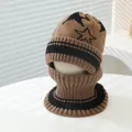 Dettaglio della trama del set invernale in maglia marrone e nero con motivo a stelle - Bambini (3-8 anni) / caffè