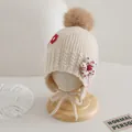 Close-up of knit earflap hat for kids featuring decorative flowers and a brown pompom - Children Elastic Style / Beige
