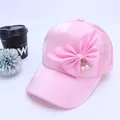 Detalle de gorra rosa de malla con gran lazo de seda y colgante de cereza perlada - Niños 2-6 Años 50-52cm / Rosa