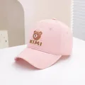 Detailed view of pink cotton baseball cap with 3D bear patch and KIMI embroidery - 50-54cm / Pink