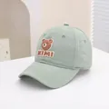 Detailed close-up of bean green kids baseball cap with 3D cartoon bear and KIMI patch - 50-54cm / Green