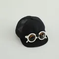 Dettaglio cappellino bebè con occhiali da sole bianchi e rete nera traspirante - Nero