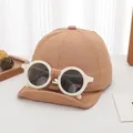 Detail of a brown cotton baby baseball cap featuring decorative white round sunglasses - Infant Style / Light Coffee