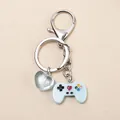 Dettaglio di un portachiavi a forma di mini controller blu con ciondolo a cuore verde - Blu