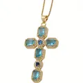 Macro detail of a gold cross pendant with blue zircon stones and white crystals - Blue