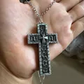 Vintage gothic cross necklace with silver snake motif pendant held in hand - Silver