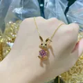 Macro detail of a 14K gold plated rabbit pendant with a large pink cubic zirconia stone - Pink