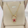 Detail view of 14K gold plated rabbit pendant with red zircon stone on silk padding - Red