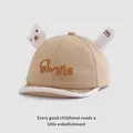 Detail van kaki baby baseballpet met Smile borduursel en schattige 3D-oren op grijze basis - Baby Maat / Khaki