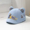 Detail van lichtblauwe babycap met beer-patch en 3D mesh oortjes in zachte setting - Peutermaat / Hemelsblauw