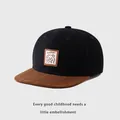 Detalle del parche de oso Lucky en la gorra hip hop de visera plana marrón y negra - 50-54cm / Negro