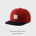 Detalle de gorra snapback infantil roja y negra con parche de cuero Lucky bear - 50-54cm / Burdeos