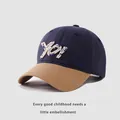 Close-up of navy and khaki baseball cap featuring YO! letter embroidery and firm stitching - 50-54cm / Navy Blue