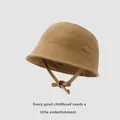 Close-up of brown cotton kids bucket hat featuring a cloud leather patch and windproof cord - Dark Khaki / 48-52cm