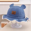 Détail d'un chapeau de soleil bébé avec oreilles d'ours et écusson sourire Lucky - Enfants 1-3 Ans / Bleu