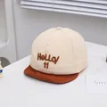 Détail de casquette bébé avec broderie HeLLO 11 et texture en coton doux beige - Bambin / Beige