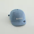 Light blue denim baseball cap for kids featuring a white embroidered smile face and nice text - NICE Mid Blue Denim