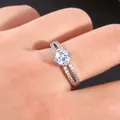 Close-up of a double-layered zircon ring on a finger with split shank and pavé diamonds - US 7 / Silver