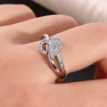Crossed silver ring featuring a micro-paved zircon heart and high polish finish - US 7 / Silver