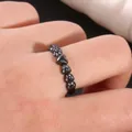 Macro shot of black heart ring with micro-pave cubic zirconia on a female finger - US 7 / Black