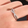 Detailed view of infinity cross ring with micro-pave cubic zirconia on model's finger - US 7 / Silver