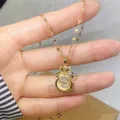 Macro detail of gold money bag pendant with cat eye stone and micro-pave dollar sign - White (Champagne Cat's Eye)