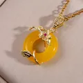 Exquisite Chinese style yellow jade donut necklace with gold flower pendant on silk background - Bright Yellow