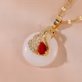 Golden swan necklace with red gemstone and white stone disc on orange silk background - Swan Pendant Style (XL2844)