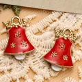 Makroaufnahme roter Emaille-Weihnachtsglocken mit goldenem Elchgeweih auf weißer Spitze - Roter Glocken-Stil