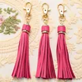 Detailed view of hot pink leather tassel charms with gold lobster clasps for handbags - Rose Red