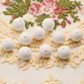 Close-up of 15mm white silicone round beads with center holes on lace fabric - 10 Pieces/Pack (15mm) / White