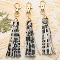 Three zebra print PU leather tassels with gold lobster clasps on white lace background - Grey Leopard Print