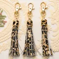 Detailed view of leopard print PU leather tassels with gold lobster clasps on lace fabric - Yellow Leopard