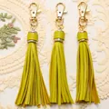 Detailed close-up of lime green PU leather tassels with gold-tone lobster clasps for bags - Matcha Green