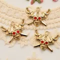 Gros plan détaillé de breloques crâne de pirate doré avec strass rouges pour la bijouterie - Style Crâne de Pirate Doré Yeux Rouges