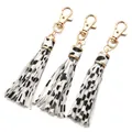 Three-piece cow print PU leather tassel keychains with golden lobster clasps on white base - White Spotted