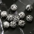 Detailed macro view of 15mm white leopard print silicone beads on dark marble surface - 10 Pieces/Pack (15mm) / White Black Pattern